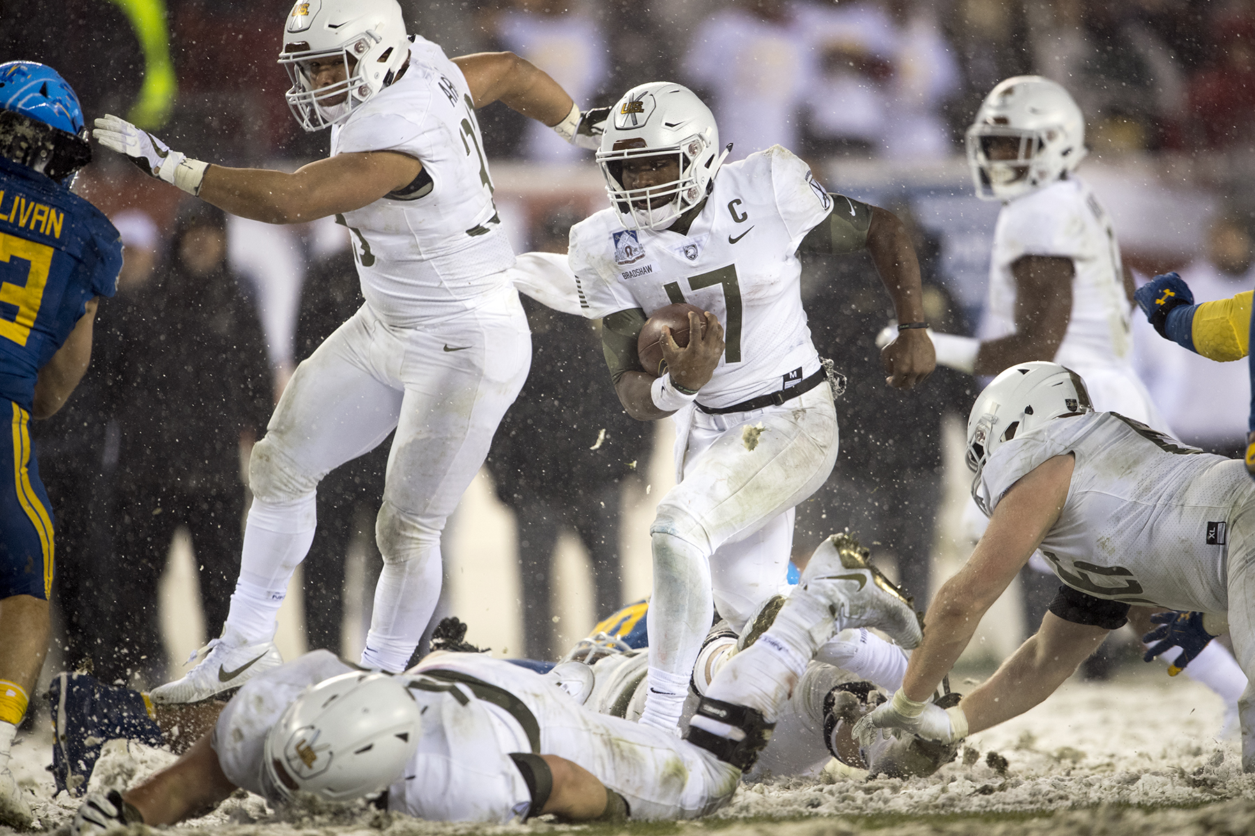 Army quarterback Ahmad Bradshaw carries the ball amid falling snow against Navy in 2017