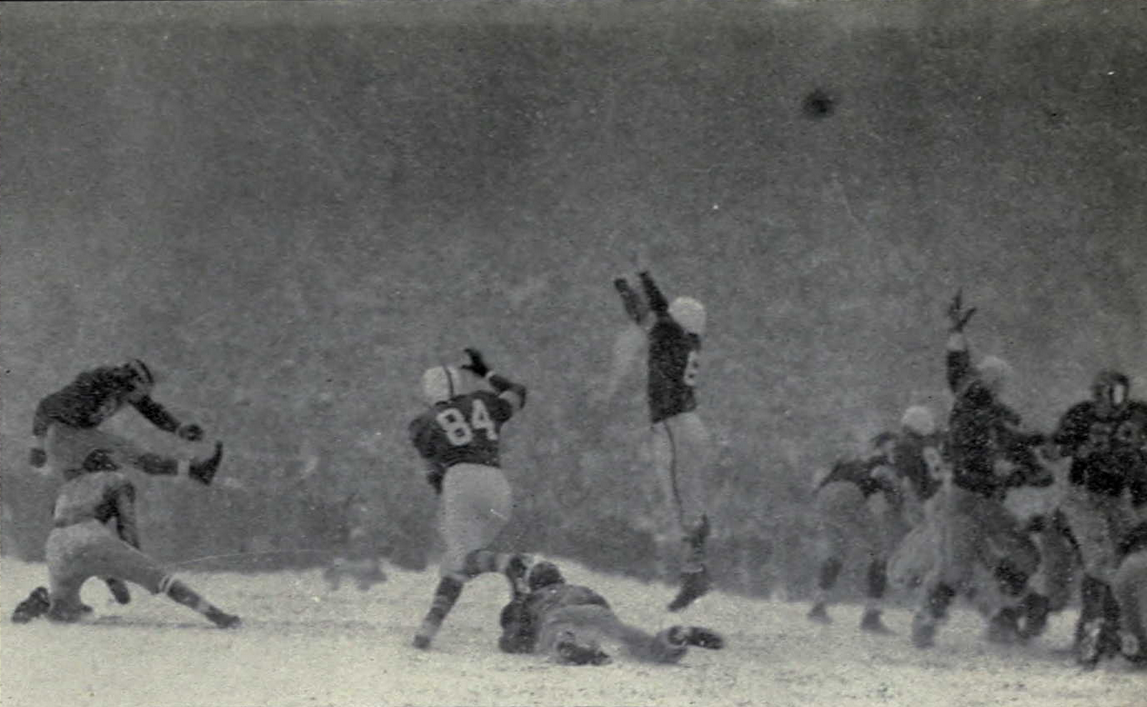 Harry Allis kicks an extra point on a snow-covered field during Michigan–Ohio State in 1950